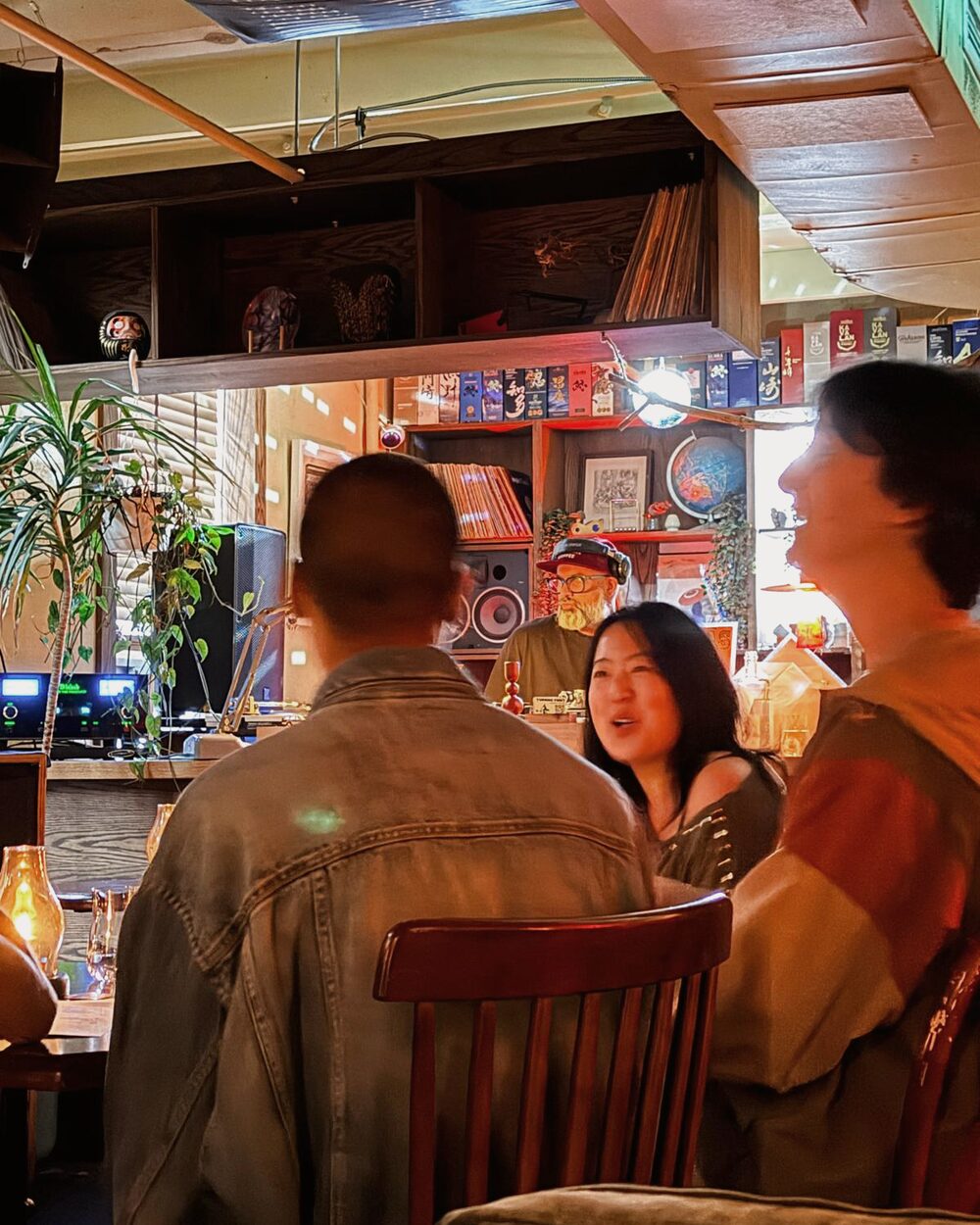 Guests talking at a candlelit table during a listening session